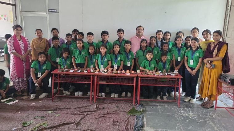 Students and teachers beside the display of handmade Ganesh idols at Janhit World School