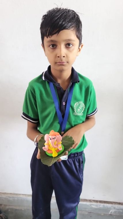 A junior student with the craft model he made at Janhit World School