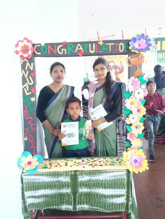 A teacher and student with an award certificate at Janhit World School