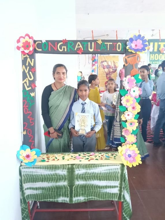 A student with his teacher holding an award certificate at Janhit World School