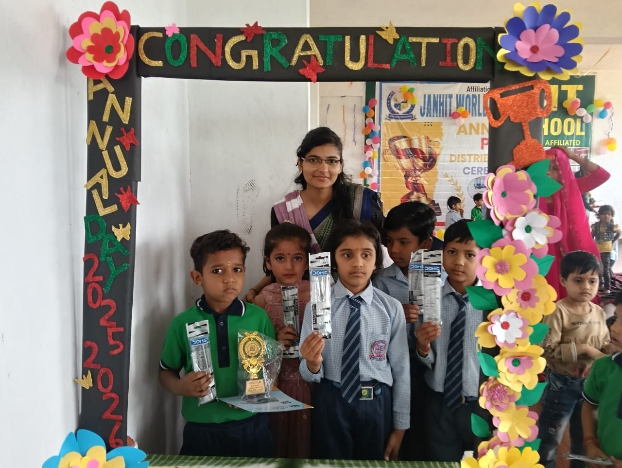 Junior students of Janhit World School showing their prizes with a teacher
